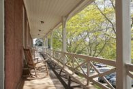 View of porch with rocking chairs.