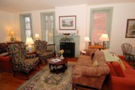 View of couch, chairs, and fireplace in sitting room.